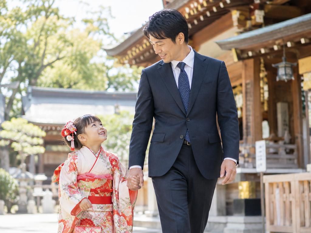 七五三でネイビーのスーツを着た父親と着物姿の子どもが神社を歩く様子